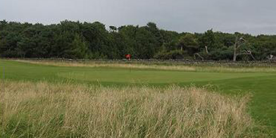 A red flag stand in center of the golf course